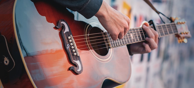 Un hombre tocando una guitarra en uno de los mejores lugares en TX para los músicos