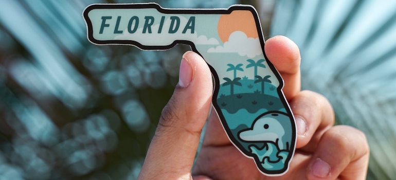 a person holding Florida magnet 
