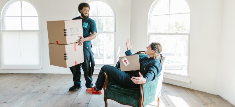 Professional movers holding boxes before relocating to one of the best Houston neighborhoods to move to