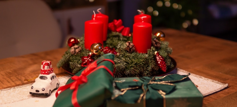 Unlighted Red Advent Candles on Table Beside Green Gift Boxes 