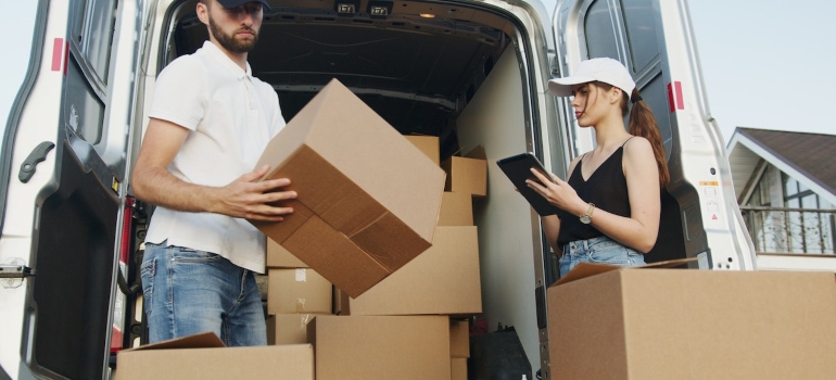 a couple loading boxes into a truck before moving to San Antonio