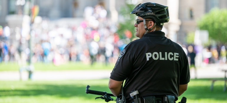 un oficial de policía en bicicleta en el parque mirando a su alrededor 