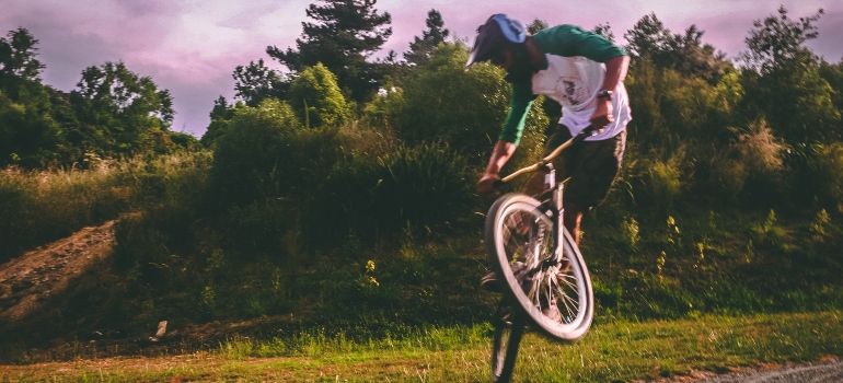 un hombre joven juega con una bicicleta en una pista de ciclismo