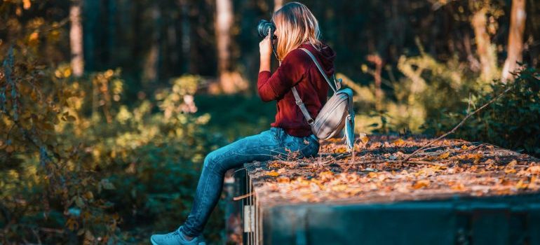 A young woman taking photos with her camera thinking about moving from Kirby TX to Ohio in 2023