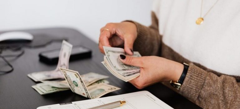 a woman counting money before moving to San Antonio 