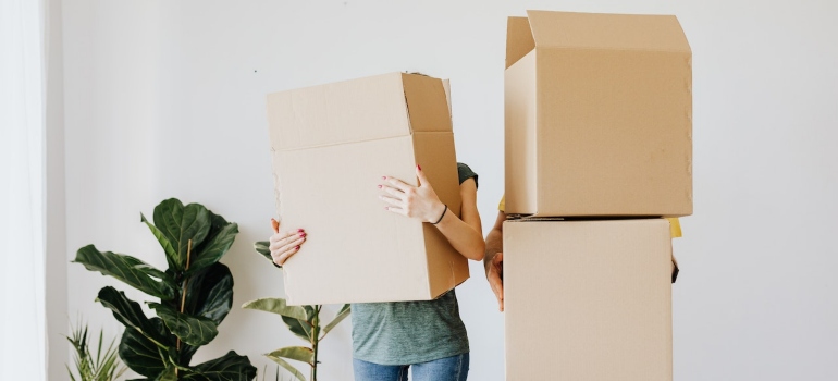 Two people holding boxes