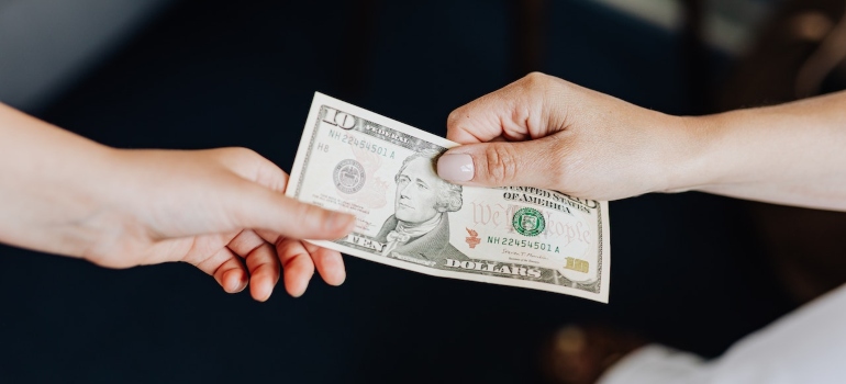 two people holding a dollar bill 