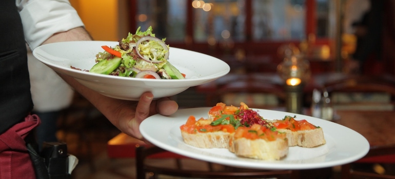 a waiter holding plates of food