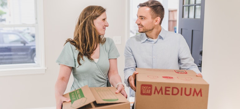 a couple carrying boxes before leaving Texas around the holidays