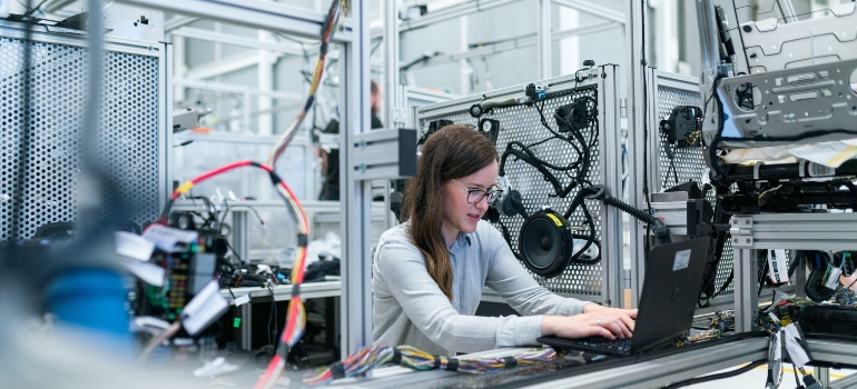 a young girl is doing a technological job and typing data into a laptop