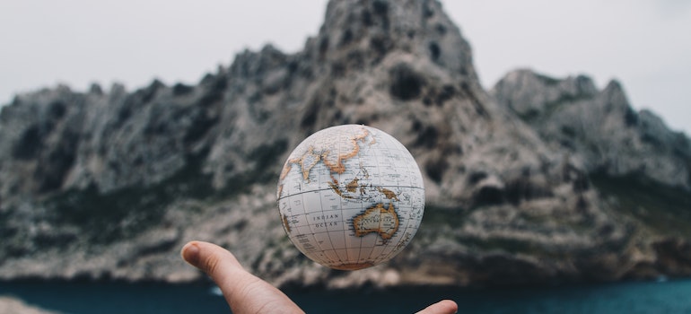 a globe flying above a hand