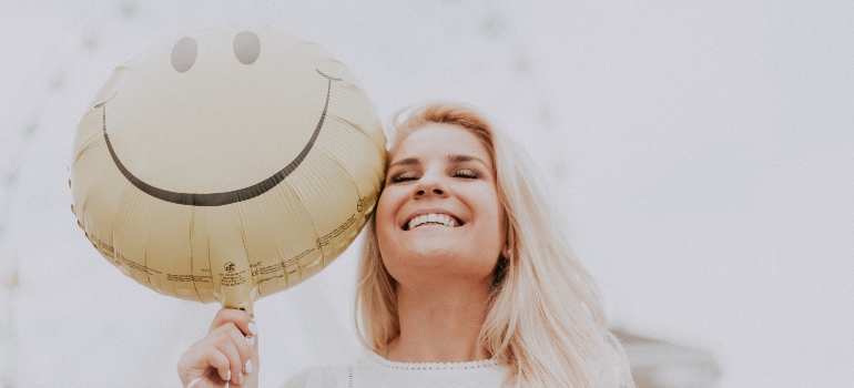 mujer sonriendo y sosteniendo un globo