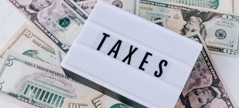 a sign that says taxes on a pile of money