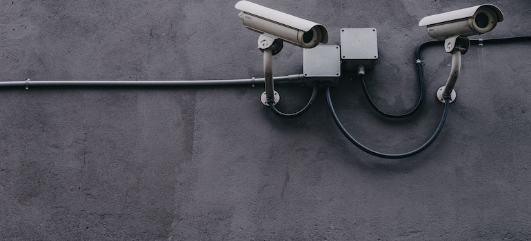 white security cameras on a grey wall
