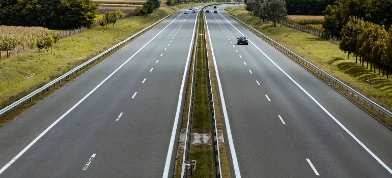 Casi vacía carretera con algunos árboles en el lado de la carretera