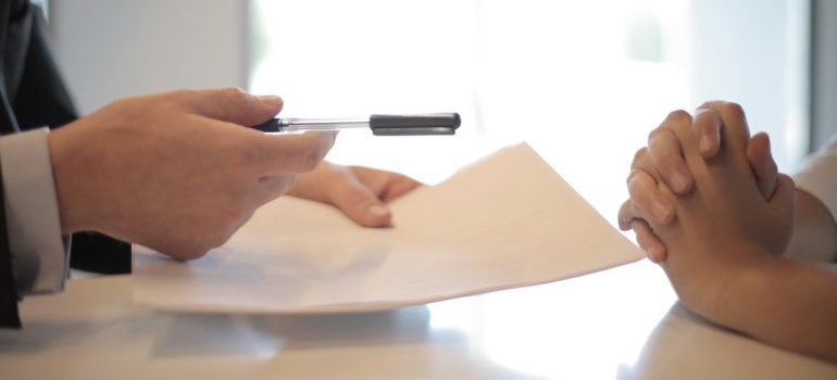 man giving contract to woman to sign