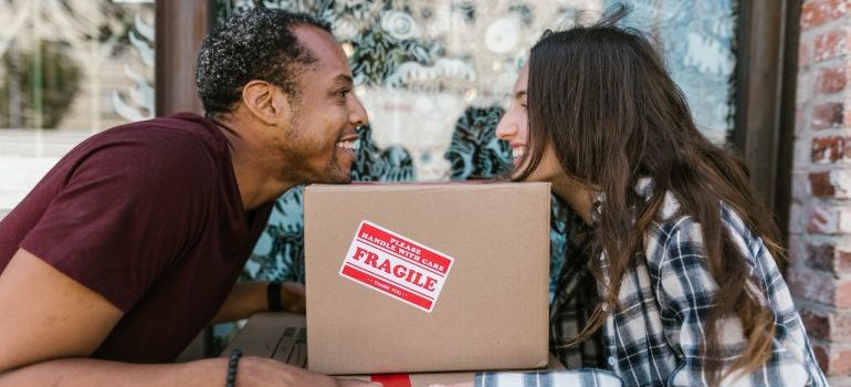 man and woman holding boxes