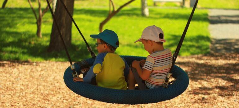 two kids sitting on swing