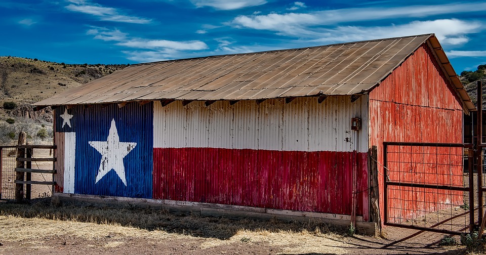 Old barn with a Texan flag painted on the roof