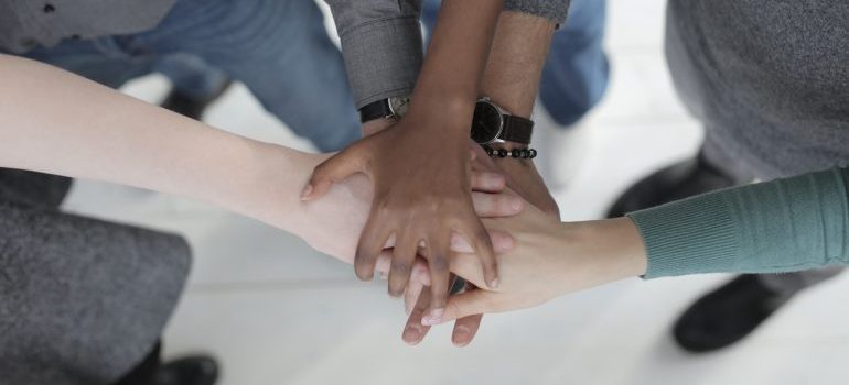 diverse people joining hands