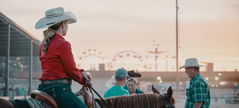 Una mujer sobre un caballo en un rodeo.