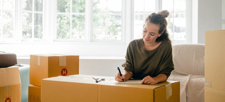 mujer escribiendo en una caja