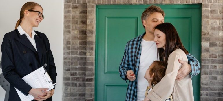 la familia de pie con un agente de bienes raíces