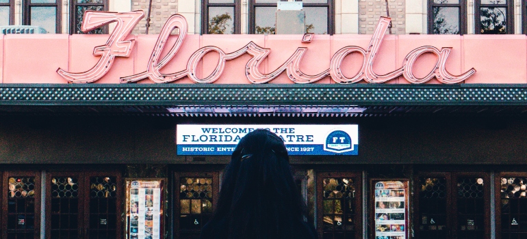 A woman standing in front of the Florida sign