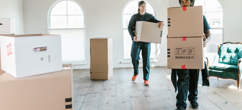 Profesional de las empresas de mudanzas cargando cajas en el apartamento