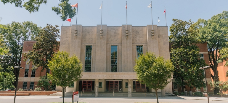 A concrete building with flags on the top