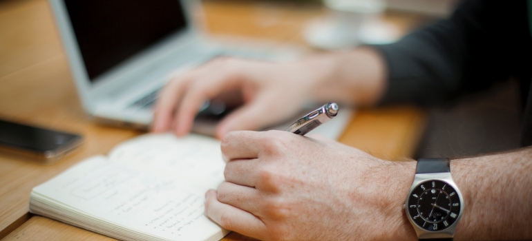 Un hombre escritura, mientras que el pensamiento acerca de los factores para reinventarse a sí mismo y a su carrera 