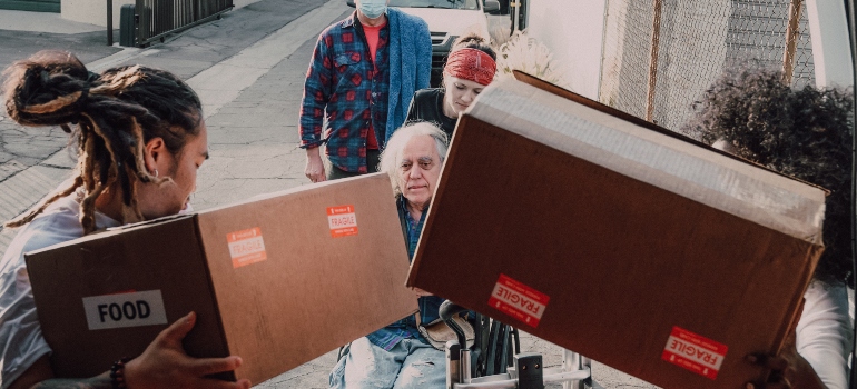 People placing boxes in a moving truck
