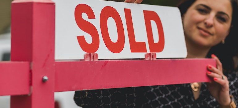 picture of woman holding sold sign