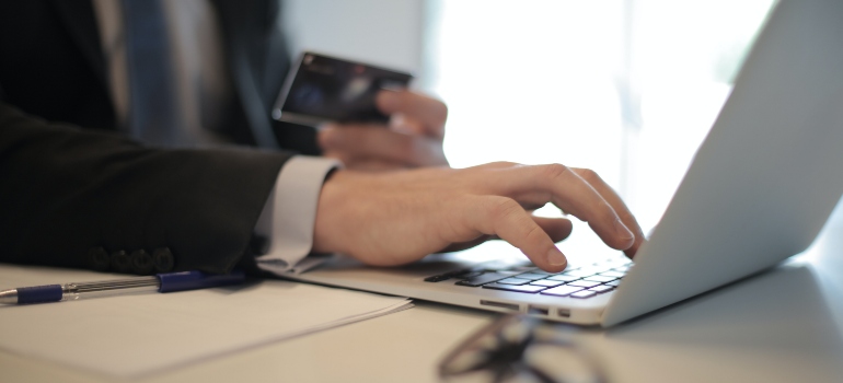 a business man typing on a laptop, searching Austin vs. Houston job market