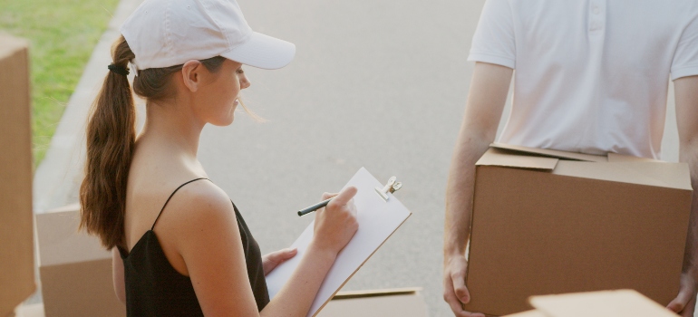 mujer tomando notas para evitar la falta de comunicación con las empresas de mudanzas cuando se mueve a otro en Texas