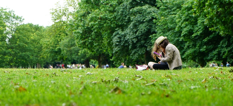 a woman in a park deciding between Austin vs. Houston