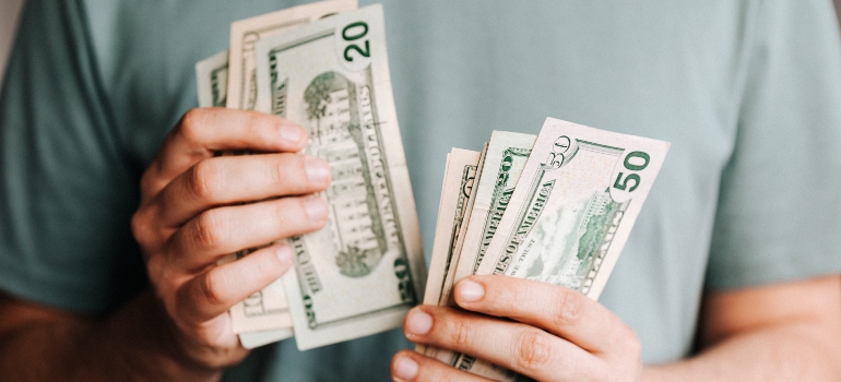 a man counting money thinking about moving to South Carolina vs. Virginia