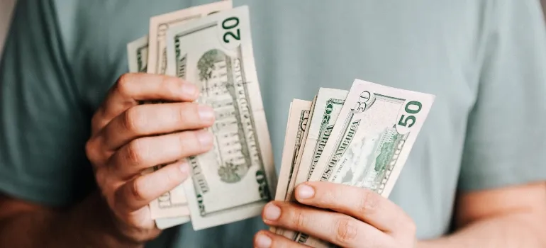 un hombre a contar el dinero de pensar acerca de las razones más comunes que la gente pase de Houston a Dallas