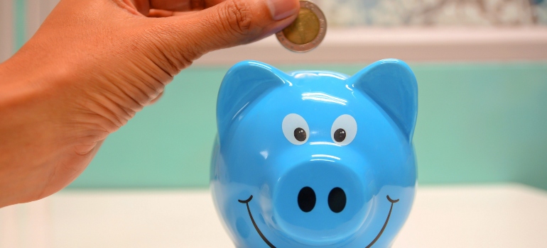 a person putting a coin into a piggy bank