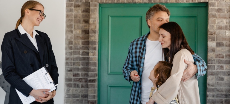 Happy family standing with real estate agent after moving from Florida to a small place in Texas.