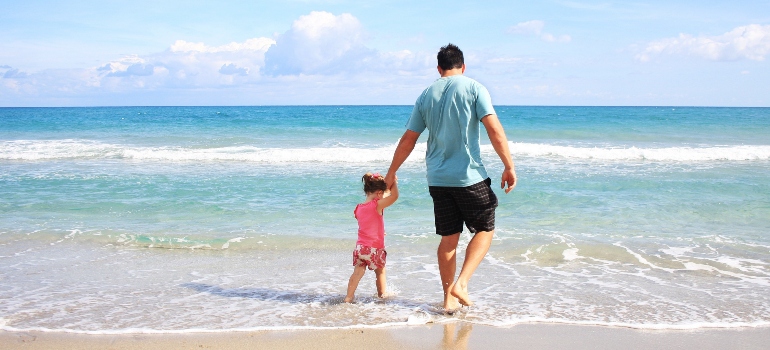 a man and a child on a beach choosing South Carolina vs. Virginia to move to