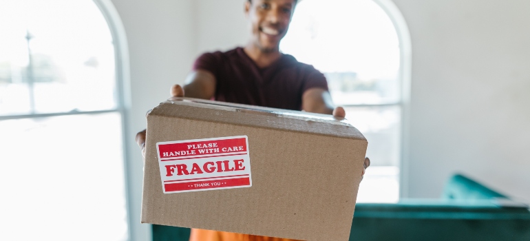man holding a box labelled "fragile"