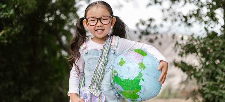 a child holding a globe