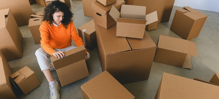 a woman looking through moving boxes