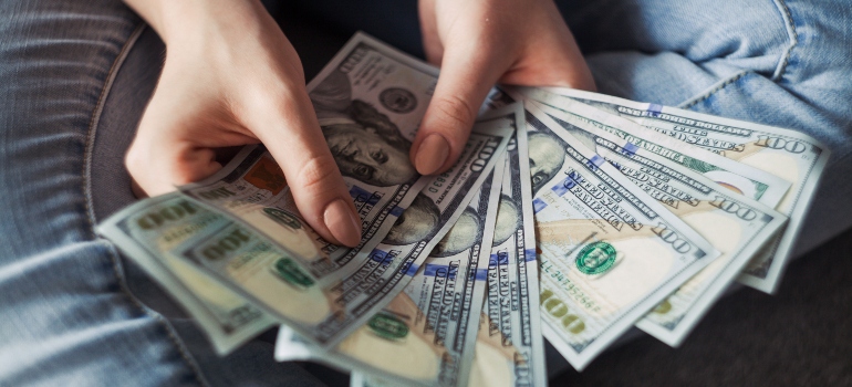 a woman counting money before moving from Dallas to San Antonio