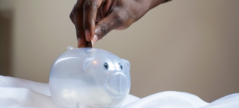 a man putting a coin in a piggy bank