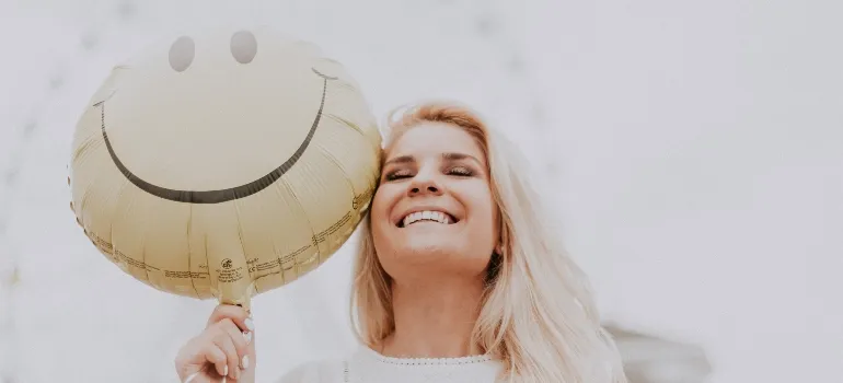 a woman holding a balloon and smiling
