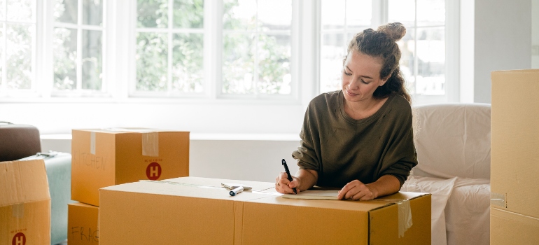 a woman writing on a box