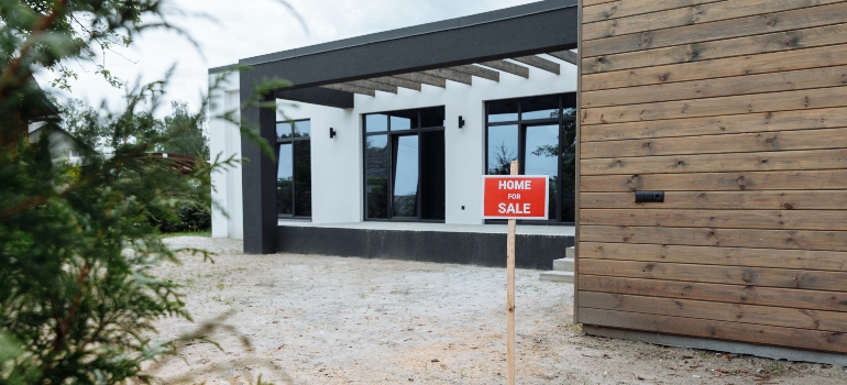 a house with a "for sale" sign in front