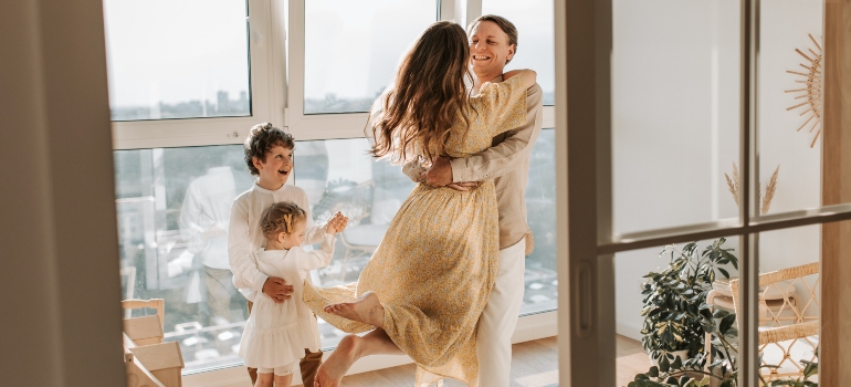 los padres de familia con dos niños felices para mover a Cypress con su familia